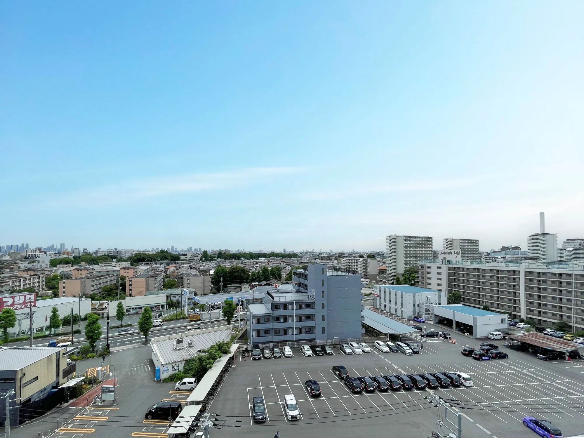 京王線芦花公園駅周辺の駅や道路、駐車場を含む周辺施設が中心の都市景観