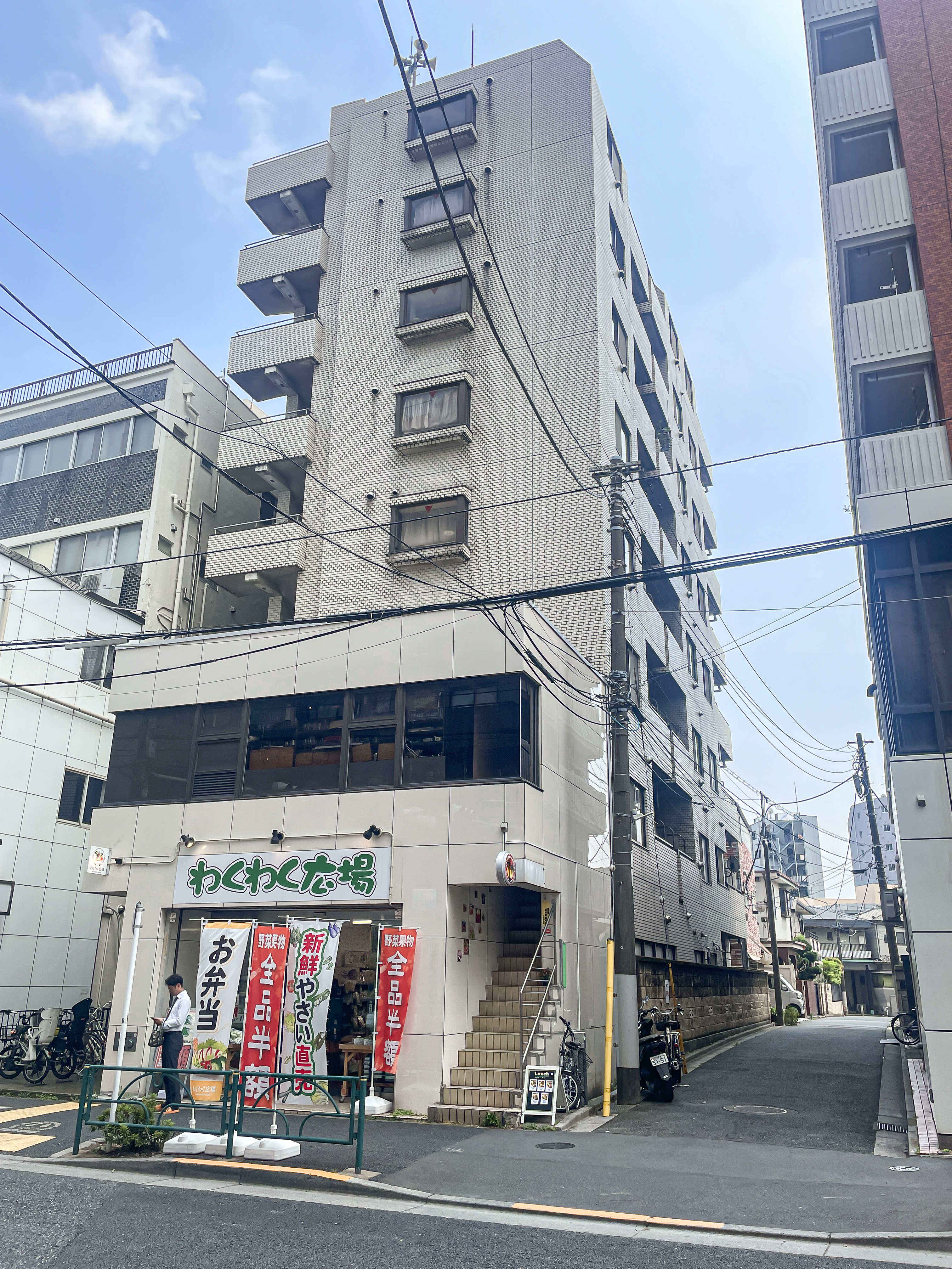 建物の外観が主体で、店舗と周辺道路を含む街並みを撮影した画像